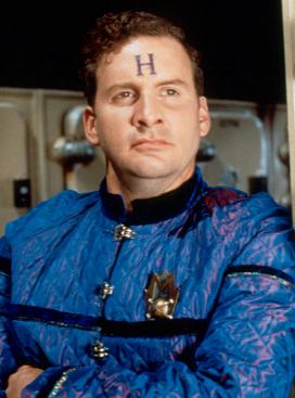 Photo de Arnold Rimmer. Il a la lettre H sur le front pour dire que c'est un hologramme. Photo de Arnold Rimmer. Il a la lettre H sur le front pour dire que c'est un hologramme.