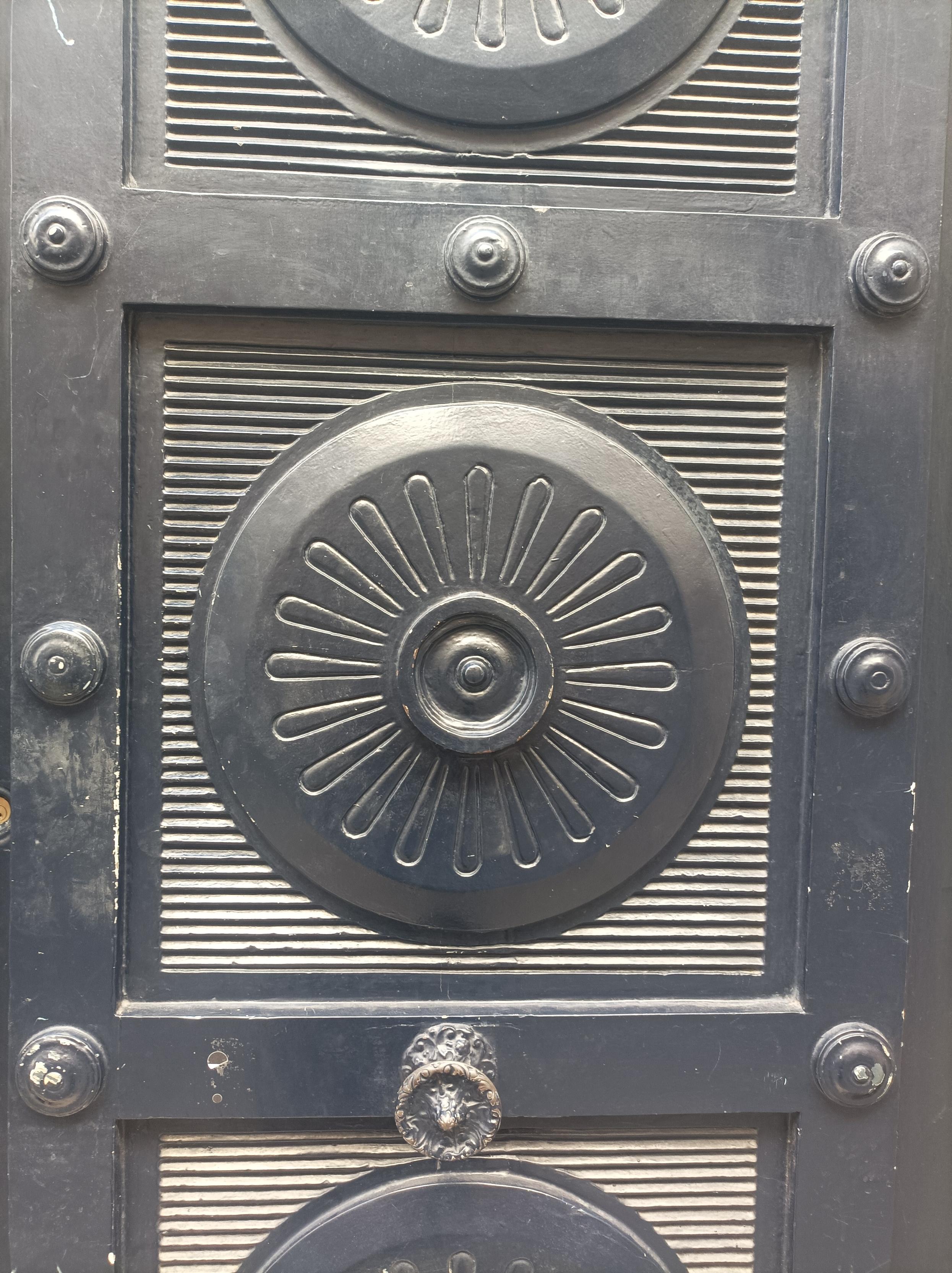 Détail d'une porte représentant une cercle, avec une fleur dessinée dans celui ci
